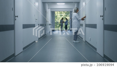 Medical staff and patients in modern hospital or medical center corridor Medical staff and patients in modern hospital or medical center corridor 106919094