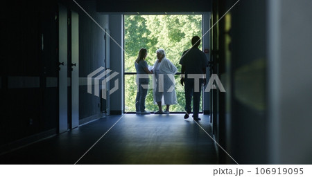 Medical staff and patients in dark hospital or medical center hallway Medical staff and patients in dark hospital or medical center hallway 106919095