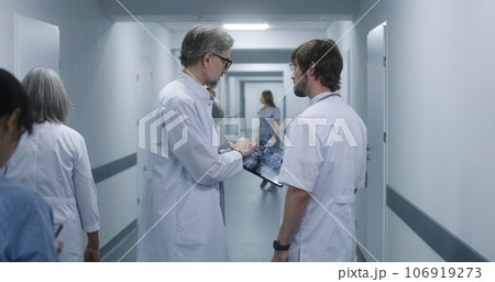 Doctor shows MRI, CT brain scan image to colleague using tablet 106919273