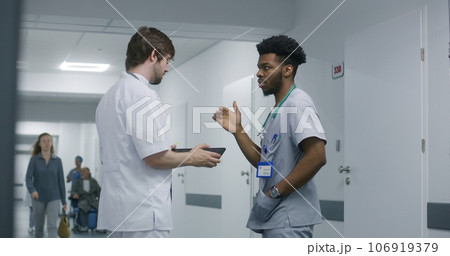 Professional doctor shows MRI or CT scan results to colleague Professional doctor shows MRI or CT scan results to colleague 106919379