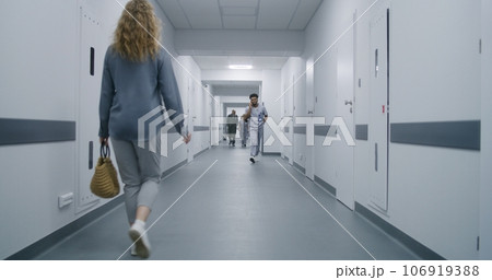 Woman goes corridor and asks doctor way to cabinet 106919388