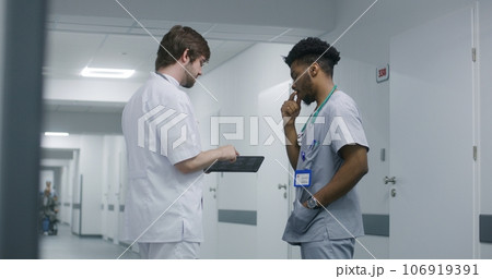 Professional doctor shows MRI or CT scan results to colleague Professional doctor shows MRI or CT scan results to colleague 106919391