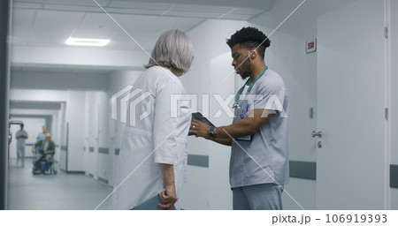 Multicultural medics discuss medical test results of patient 106919393