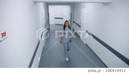Doctors, nurses and diverse patients walking in hospital hallway 106919452