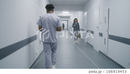 African American physician walks corridor 106919453