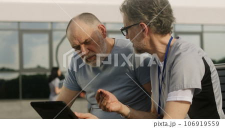 Mature doctor makes diagnosis to elderly patient 106919559