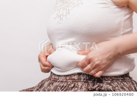【お腹の肉を摘む主婦】 106920480