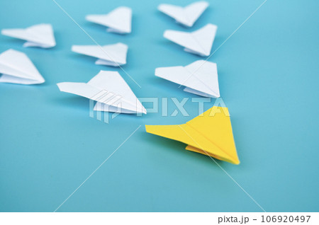 Top view of yellow paper airplane origami leading other white paper airplanes Top view of yellow paper airplane origami leading other white paper airplanes 106920497