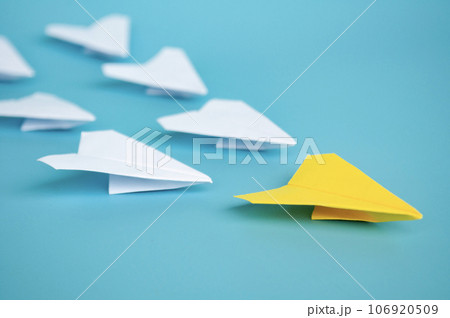 Yellow paper plane origami leading other white paper planes on blue background. Leadership concept 106920509