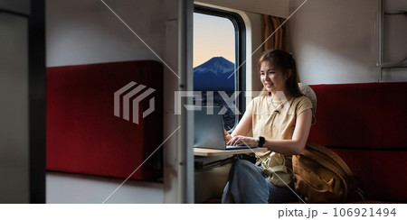 Traveler young woman travel in train. Remotely work on laptop during sitting inside . travelling tourist have small trip fuji as the background concept transport lifestyle active journey and travel 106921494