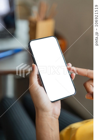 Close up image of female hands using smartphone with blank white screen in the home 106921519