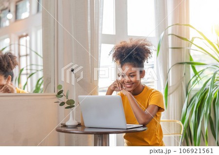 Woman african american smile sitting on desk using laptop. Relax african american lady enjoy her weekend, surfing on internet on laptop at home Woman african american smile sitting on desk using laptop. Relax african american lady enjoy her weekend, surfing on internet on laptop at home 106921561