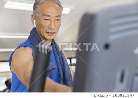 スポーツジムでエアロバイクの操作設定をする中高年男性 スポーツジムでエアロバイクの操作設定をする中高年男性 106921947