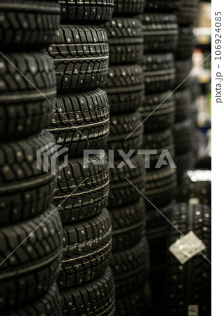 Sale of car tires for sale in the store. Many new winter tires lie horizontally. There is space for text 106924085