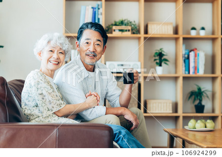 リビングでくつろぐシニアの夫婦 リビングでくつろぐシニアの夫婦 106924299