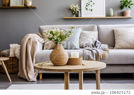 Scandinavian living room interior with design grey sofa, wooden coffee table, plants, shelf, spring flowers in vase, decoration and elegant personal accessories at home decor. 106925172