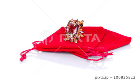 A stunning, glittering Citrine and Tourmaline ring delicately nestled within the red velvet pouch. The contrast of stark elegance against the passionate hue, invokes feelings of love, commitment. A stunning, glittering Citrine and Tourmaline ring delicately nestled within the red velvet pouch. The contrast of stark elegance against the passionate hue, invokes feelings of love, commitment. 106925812