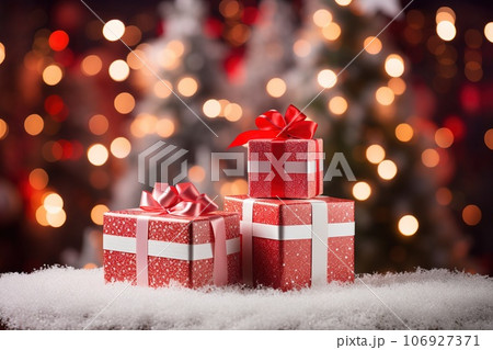 Groups of Christmas presents and balls against the backdrop of a festive Christmas tree with colored festive lights. 106927371