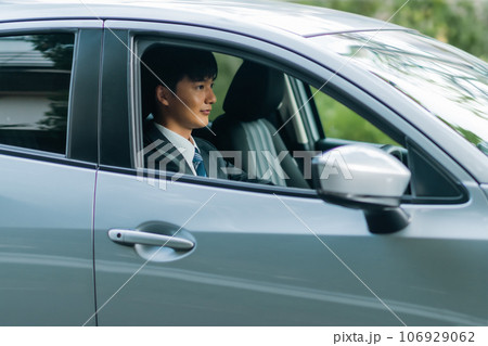 グレーの普通車を運転するスーツの男性 グレーの普通車を運転するスーツの男性 106929062