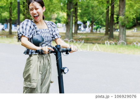 電動キックボードで爽やかに走る若い女性 106929076