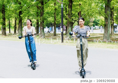 電動キックボードで爽やかに走る若い女性 106929088