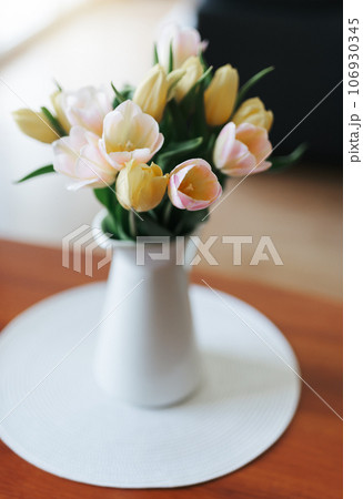 Spring tulips in a vase on the table. Spring holiday, home decor. 106930345