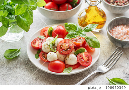 Caprese salad with tomatoes, mozzarella and basil. 106930349