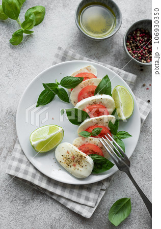Caprese salad with tomatoes, mozzarella and basil. 106930350