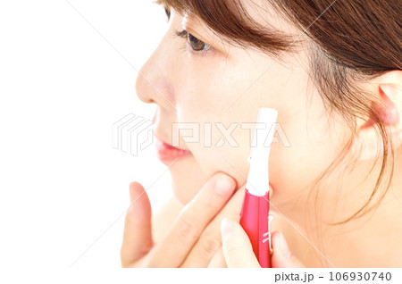 顔のムダ毛を電動トリマーで処理する女性 106930740
