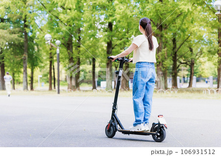 電動キックボードで爽やかに走る若い女性 電動キックボードで爽やかに走る若い女性 106931512