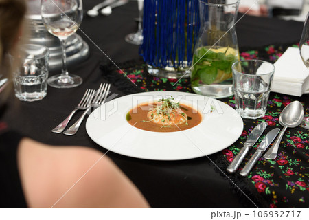 woman in a restaurant eat tomato gazpacho soup. Tasty appetizing summer tomato soup. 106932717