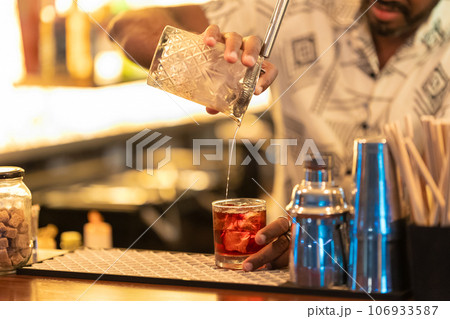 The bartender mixes the cocktail and pouring it into the glass 106933587