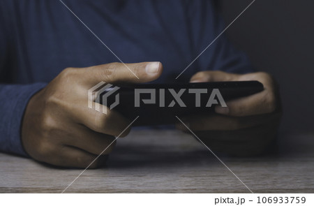 Man watching video on his mobile phone. 106933759