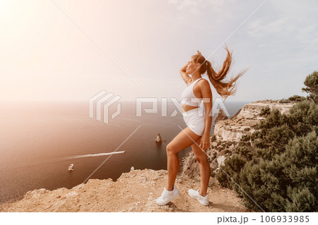 Woman sea pilates. Sporty middle-aged woman training in pilates on yoga mat by sea. concepts of health, wellness, and mindfulness in exercise, promoting the benefits of active and balanced lifestyle 106933985
