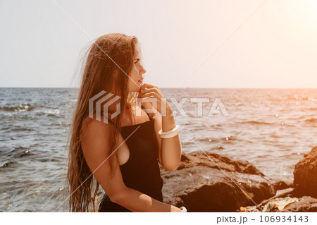 Woman summer travel sea. Happy tourist in hat enjoy taking picture outdoors for memories. Woman traveler posing on the beach at sea surrounded by volcanic mountains, sharing travel adventure journey Woman summer travel sea. Happy tourist in hat enjoy taking picture outdoors for memories. Woman traveler posing on the beach at sea surrounded by volcanic mountains, sharing travel adventure journey 106934143