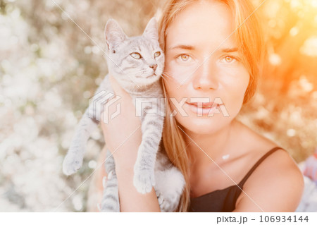 Woman summer travel cat. A woman on vacation with her pet cat enjoying a photo session on the beach. Travel and holiday concept. Woman summer travel cat. A woman on vacation with her pet cat enjoying a photo session on the beach. Travel and holiday concept. 106934144