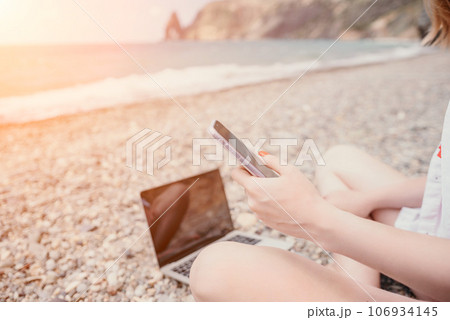 Woman sea laptop. Business woman in yellow hat working on laptop by sea. Close up on hands of pretty lady typing on computer outdoors summer day. Freelance, digital nomad, travel and holidays concept. Woman sea laptop. Business woman in yellow hat working on laptop by sea. Close up on hands of pretty lady typing on computer outdoors summer day. Freelance, digital nomad, travel and holidays concept. 106934145