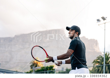 Tennis player preparing to serve a tennis ball Tennis player preparing to serve a tennis ball 106934362