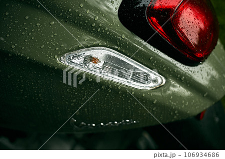 Close up green motorcycle scooter with raindrops Close up green motorcycle scooter with raindrops 106934686