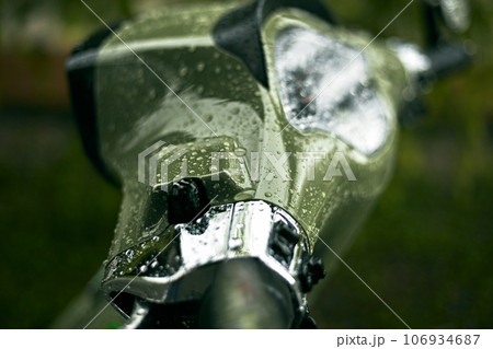 Close up green motorcycle scooter with raindrops 106934687