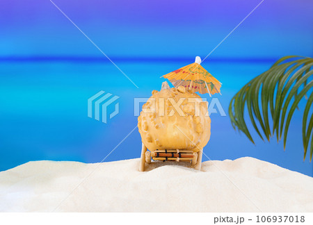 Halloween and Thanksgiving party on beach. Pumpkin on sun lounger on sand with palm tree. Autumn season on background of ocean in hot countries. Copy space 106937018
