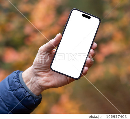 Hand holding mobile phone screen mock up over fall background 106937408