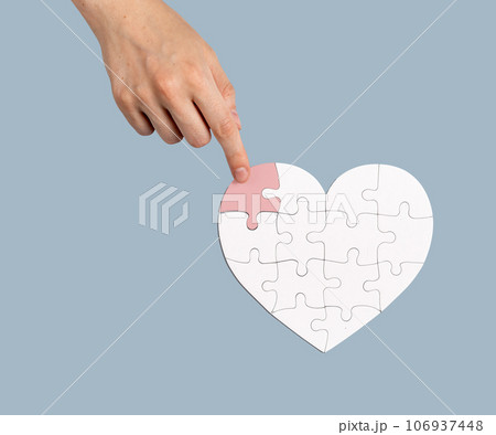 The final touch. Placing the missing puzzle piece to heart-shaped jigsaw. Help, donation concept The final touch. Placing the missing puzzle piece to heart-shaped jigsaw. Help, donation concept 106937448