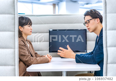 プライベートブースで話をするビジネスマンとビジネスウーマン 106937482