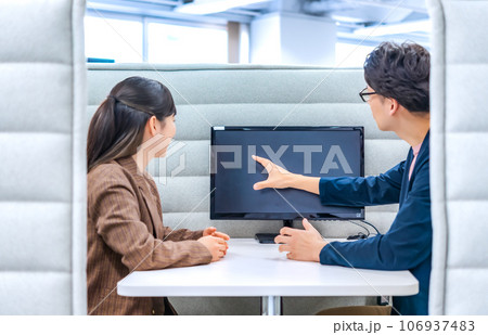 プライベートブースで話をするビジネスマンとビジネスウーマン 106937483