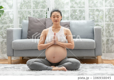 Happy Calm Pregnant Woman deep breath with fresh air do yoga lotus pose comfortable at home,Pregnancy of young woman relax with yoga to meditation for healthy life,Yoga Motherhood and Pregnant Concept 106938045