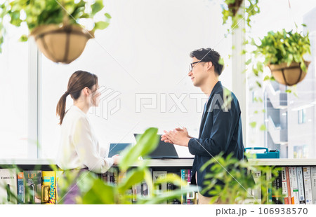 フリーアドレスのオフィスで仕事をするビジネスマンとビジネスウーマン 106938570