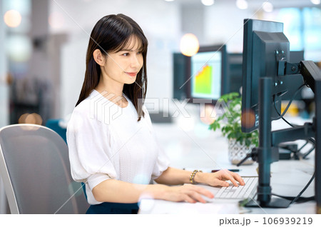 笑顔でパソコンを操作するビジネスウーマン 笑顔でパソコンを操作するビジネスウーマン 106939219