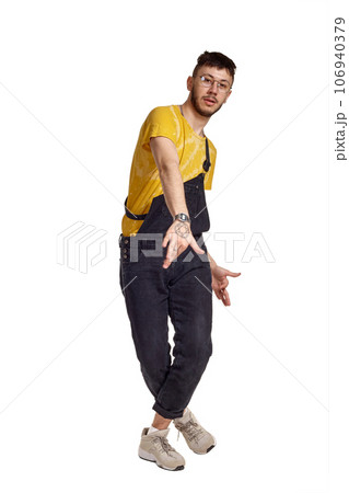 Full-length portrait of a funny guy dancing in studio isolated on white background. 106940379