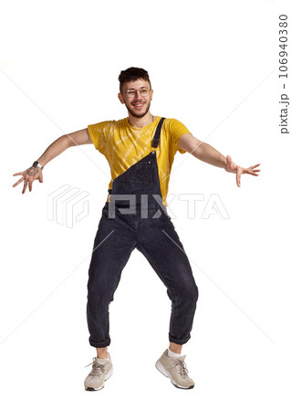Full-length portrait of a funny guy dancing in studio isolated on white background. 106940380
